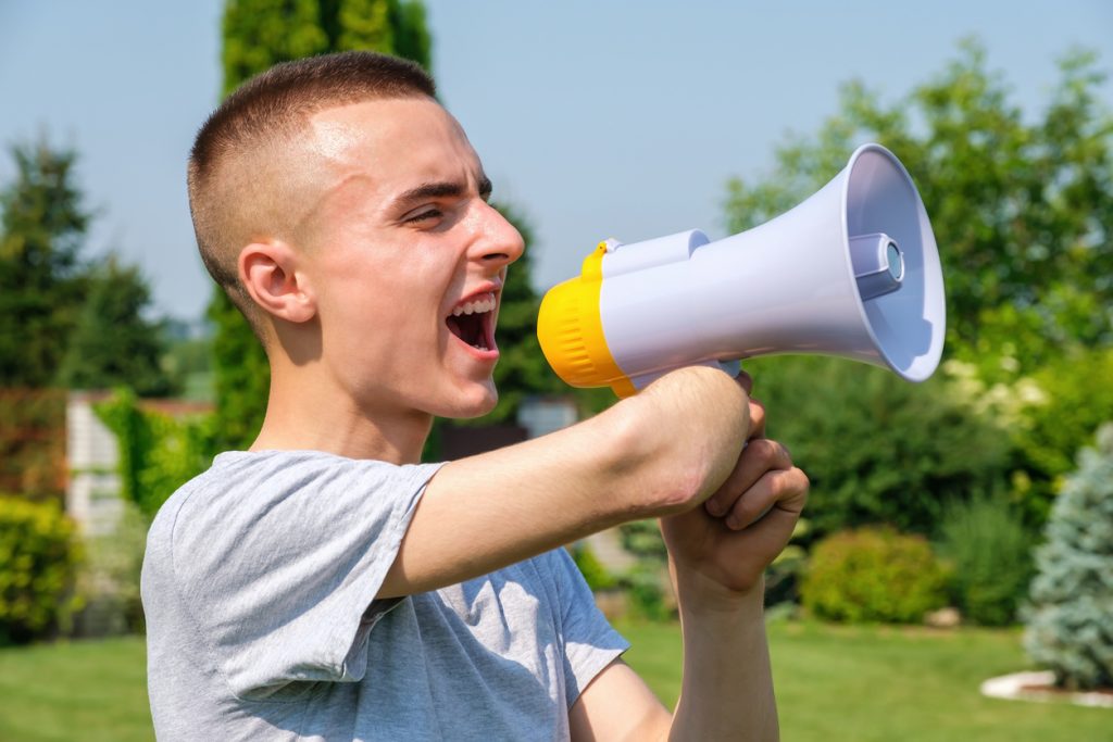 Young man speaking through a megaphone.